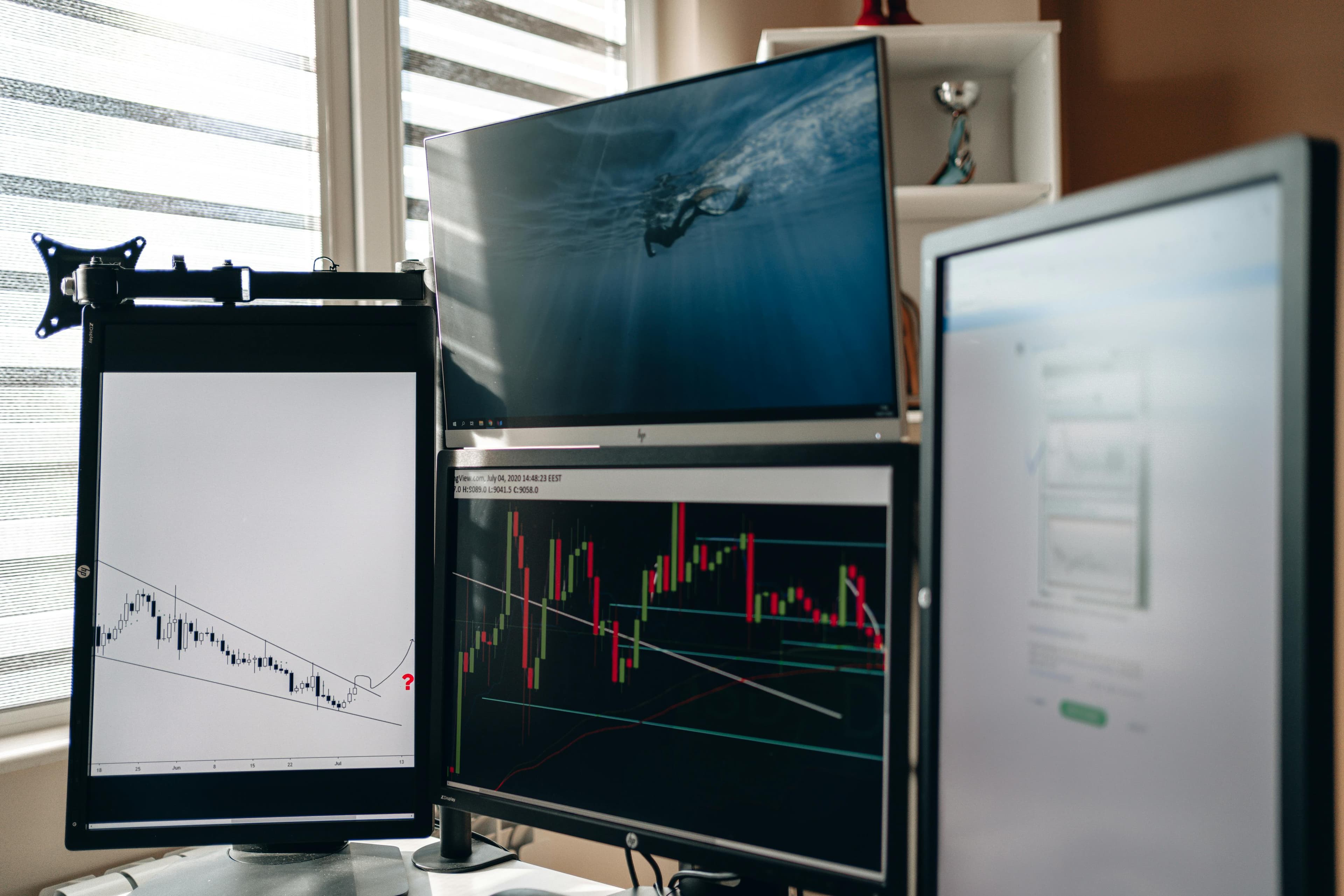 Multiple monitors showing charts and dashboards used to monitor application behavior.
