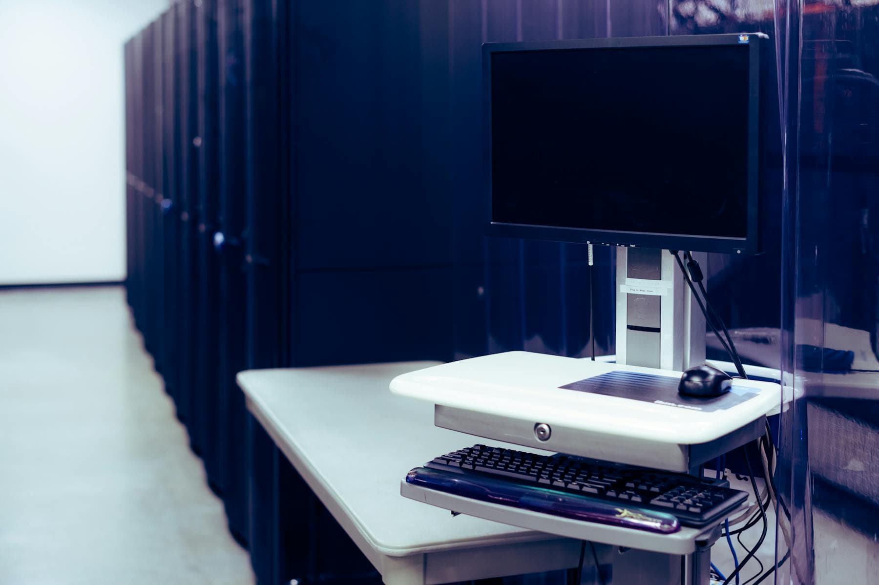 A modern workstation beside server racks representing self-hosted infrastructure.